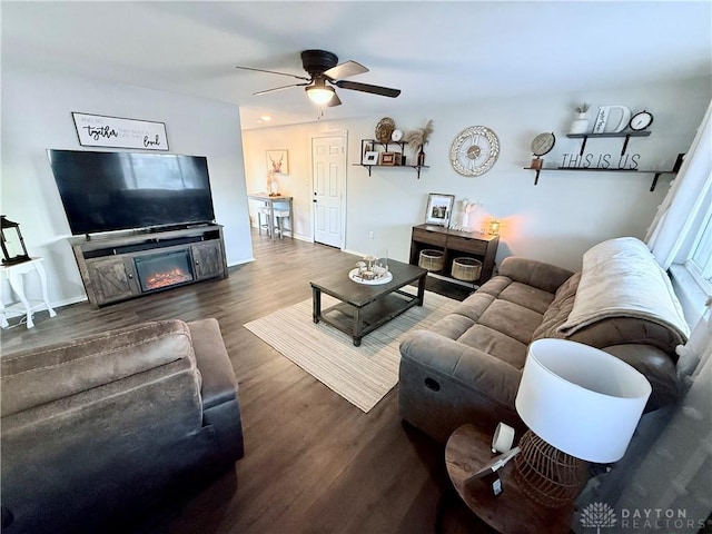 living room featuring a fireplace, ceiling fan, and dark hardwood / wood-style flooring