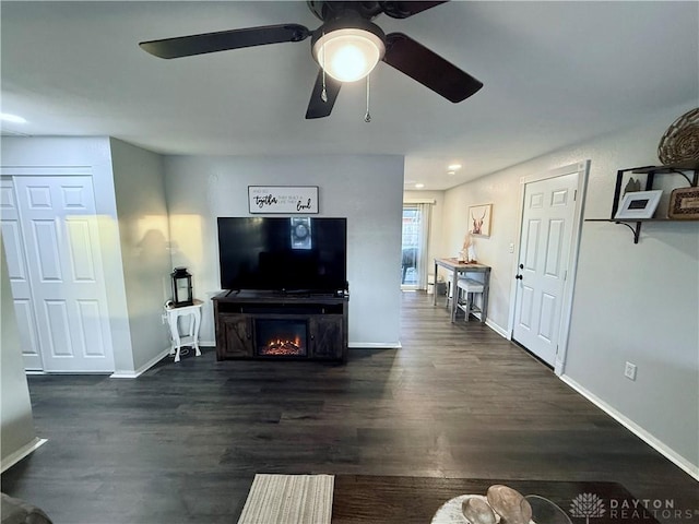 living room featuring dark hardwood / wood-style flooring and ceiling fan