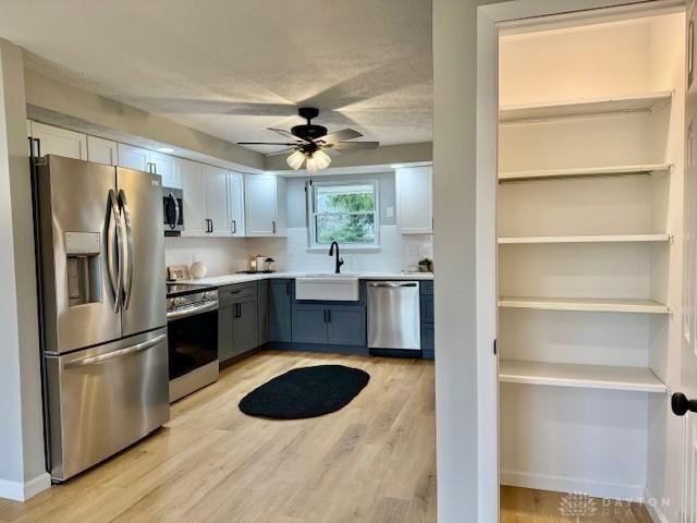 kitchen with white cabinetry, ceiling fan, sink, light hardwood / wood-style flooring, and appliances with stainless steel finishes