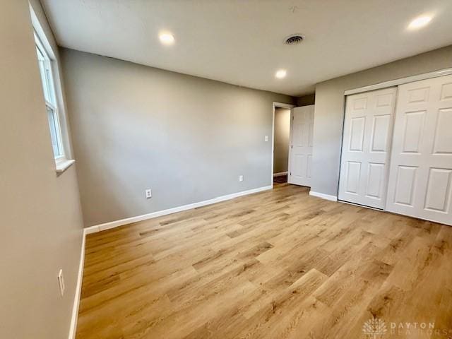 unfurnished bedroom featuring light hardwood / wood-style flooring and a closet