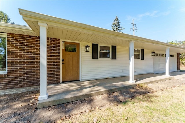 doorway to property featuring a porch and a garage