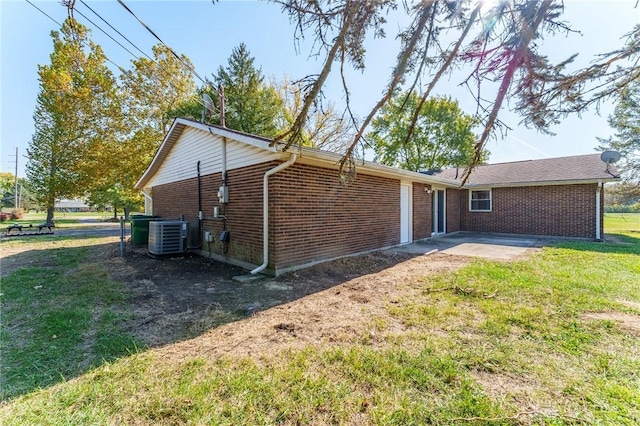 view of property exterior with central AC unit and a patio