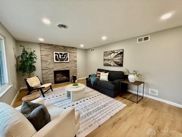 living room with a fireplace and light hardwood / wood-style flooring