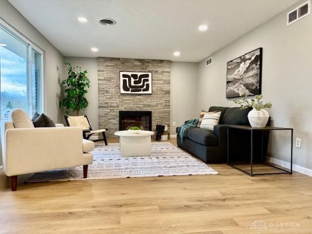 living room featuring a fireplace and light wood-type flooring