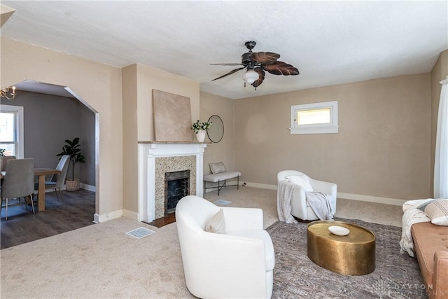 living room featuring dark carpet and ceiling fan