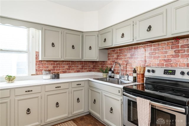 kitchen with tasteful backsplash, stainless steel range with electric stovetop, and sink