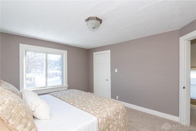 bedroom featuring a textured ceiling and carpet