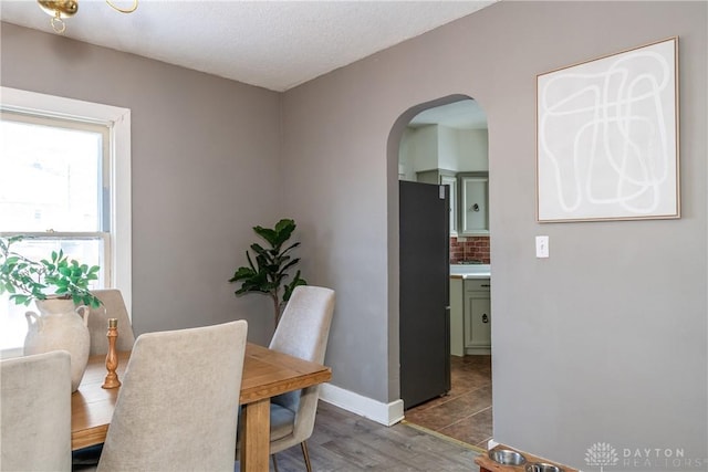 dining room with dark hardwood / wood-style flooring and a textured ceiling