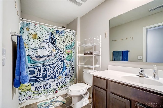 bathroom with tile patterned flooring, vanity, toilet, and walk in shower