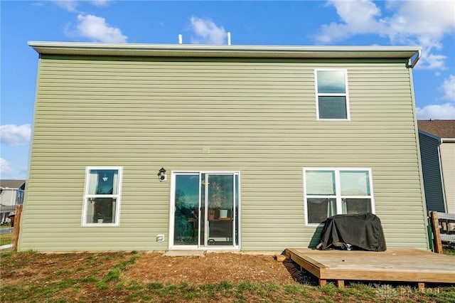 rear view of house featuring a wooden deck