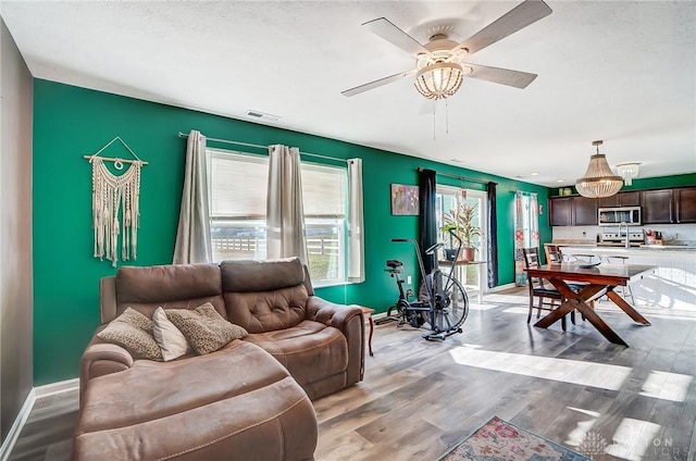 living room featuring ceiling fan and light hardwood / wood-style floors