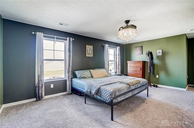 carpeted bedroom featuring an inviting chandelier