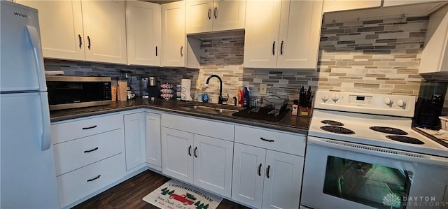 kitchen featuring decorative backsplash, dark hardwood / wood-style flooring, white appliances, sink, and white cabinets