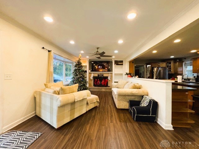 living room with dark hardwood / wood-style floors, ceiling fan, sink, and built in shelves