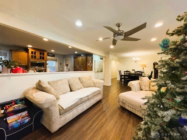 living room featuring ceiling fan and dark wood-type flooring