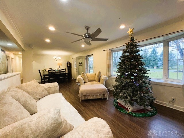 living room with dark hardwood / wood-style flooring, ceiling fan, and ornamental molding