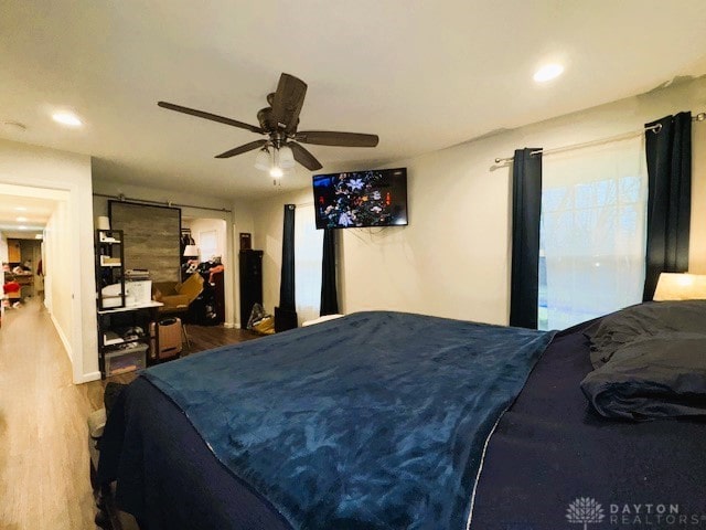 bedroom with multiple windows, ceiling fan, and hardwood / wood-style floors