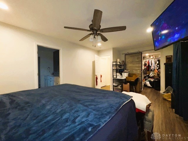 bedroom featuring ceiling fan, dark hardwood / wood-style flooring, ensuite bathroom, and a closet