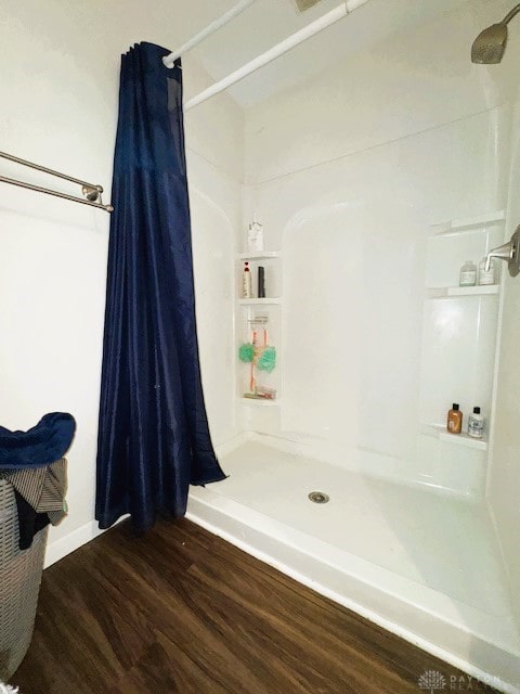 bathroom with a shower with curtain and wood-type flooring