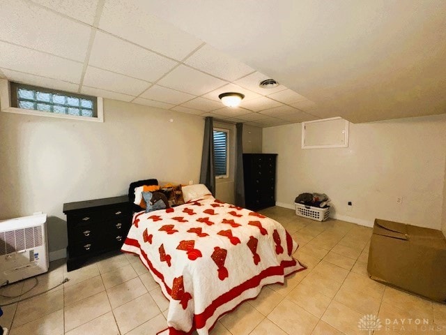 bedroom with a drop ceiling and light tile patterned flooring