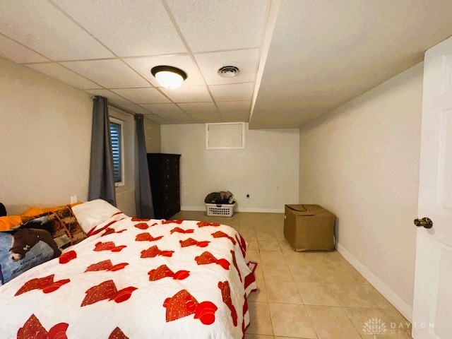 tiled bedroom with a paneled ceiling