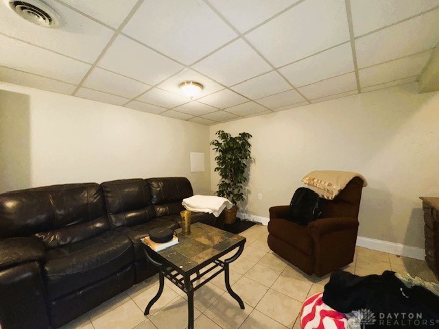 tiled living room featuring a drop ceiling