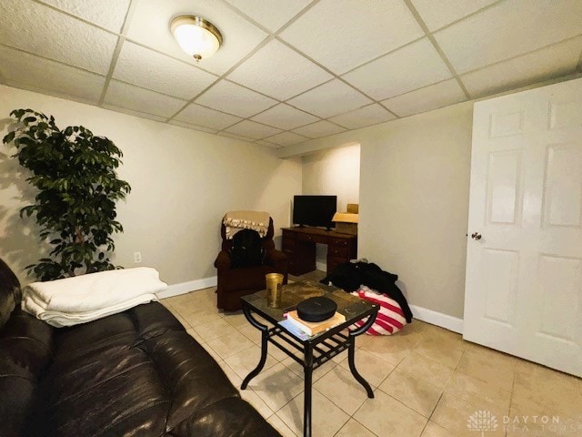 tiled living room featuring a drop ceiling