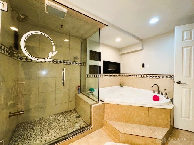 bathroom with tile patterned flooring and shower with separate bathtub