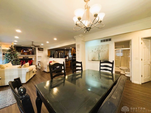 dining room with ceiling fan with notable chandelier, dark hardwood / wood-style flooring, and ornamental molding