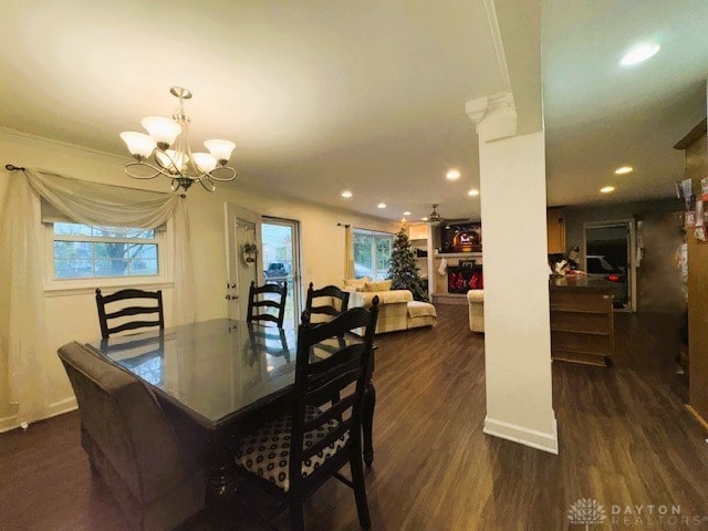 dining space with dark hardwood / wood-style flooring, ornamental molding, and an inviting chandelier