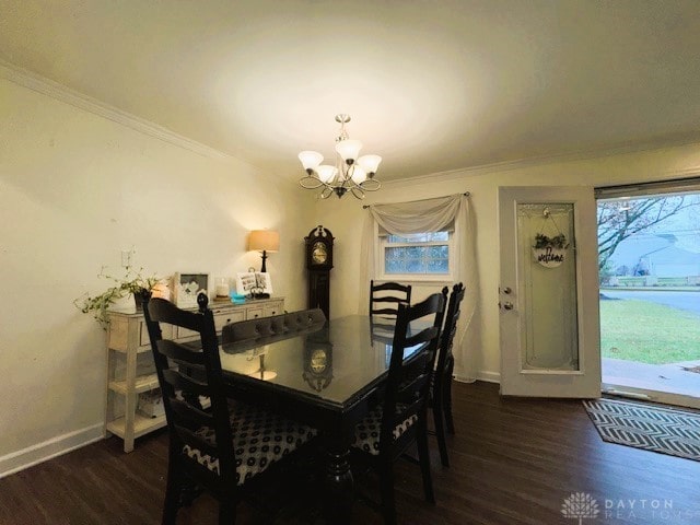 dining area with dark hardwood / wood-style flooring, an inviting chandelier, and ornamental molding