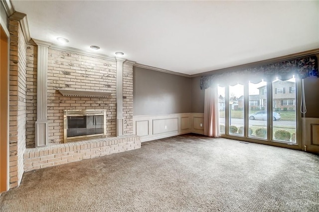 unfurnished living room featuring carpet, ornamental molding, and a fireplace