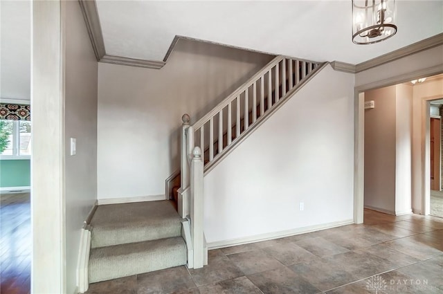 stairs featuring an inviting chandelier and ornamental molding