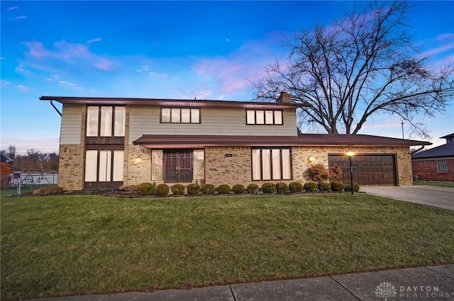 view of front of home featuring a lawn and a garage