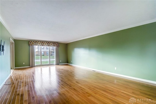 empty room with light hardwood / wood-style floors and ornamental molding