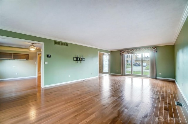 spare room featuring ceiling fan, wood-type flooring, and ornamental molding