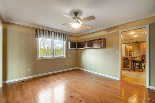 spare room featuring hardwood / wood-style floors, ceiling fan, and crown molding