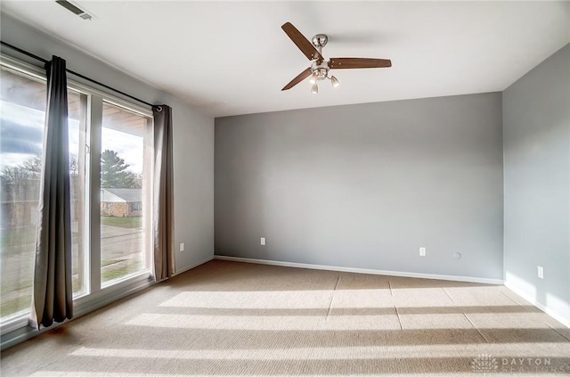 carpeted spare room featuring ceiling fan