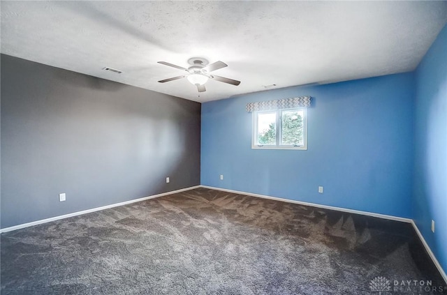 carpeted spare room featuring ceiling fan and a textured ceiling