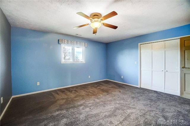 unfurnished bedroom with carpet flooring, ceiling fan, a closet, and a textured ceiling