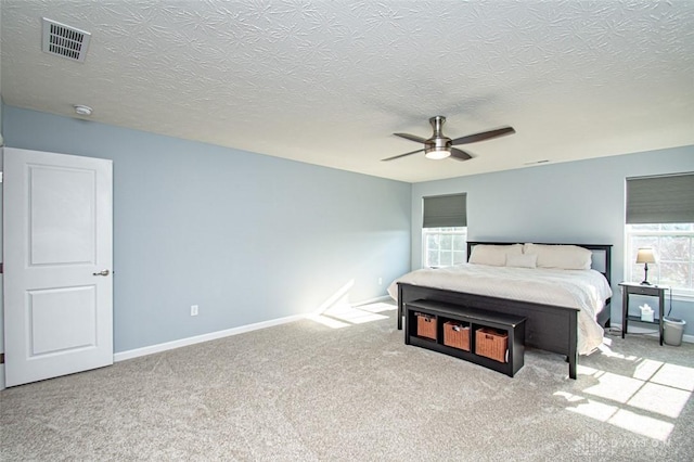 bedroom with a textured ceiling, ceiling fan, and light carpet