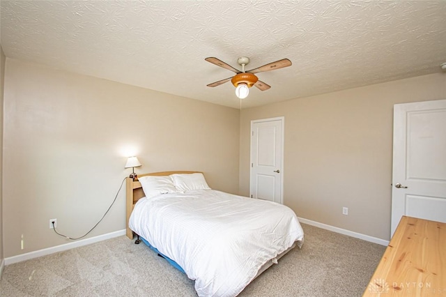 carpeted bedroom with ceiling fan and a textured ceiling