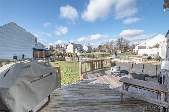 deck featuring a yard, an outdoor hangout area, a playground, and area for grilling