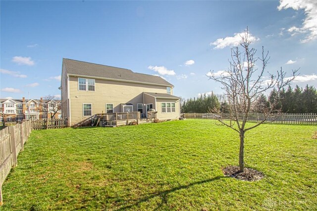 back of house with a deck and a yard