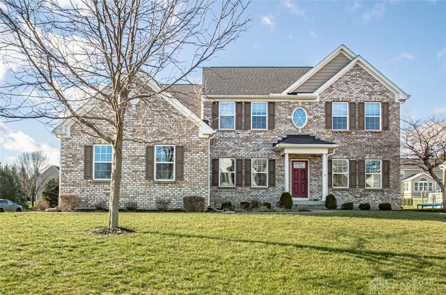 view of front of home with a front lawn and brick siding