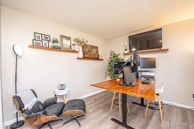 home office featuring wood-type flooring and a textured ceiling