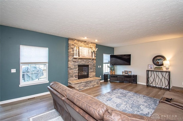 living room featuring a fireplace, hardwood / wood-style floors, and a textured ceiling