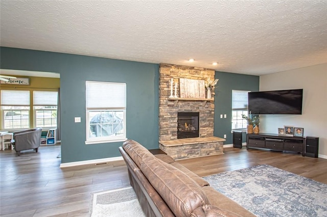 living room with a fireplace, a textured ceiling, and hardwood / wood-style flooring