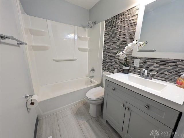 full bathroom with vanity, backsplash, toilet, and shower / washtub combination