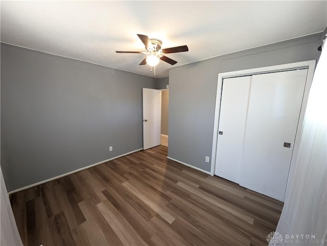 unfurnished bedroom featuring ceiling fan, dark hardwood / wood-style floors, and a closet